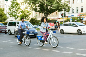 man and woman riding bicycle on road during daytime