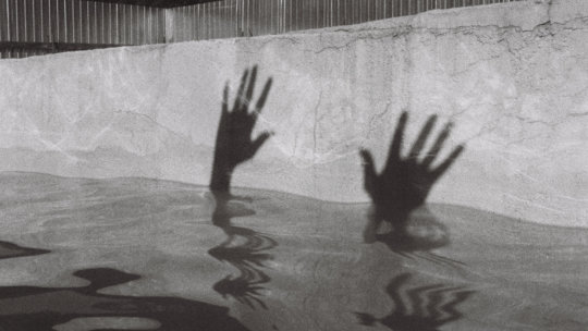 person in water in grayscale photography