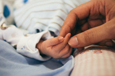 person holding baby's index finger