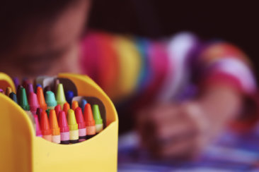 selective focal photo of crayons in yellow box