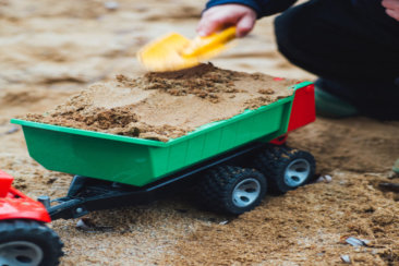 selective focus photo of toy trailer filled of brown sands