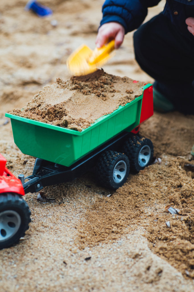 selective focus photo of toy trailer filled of brown sands